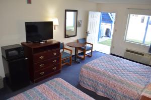 Una habitación de hotel con dos camas y un televisor de pantalla plana. en American Inn and Suites White Hall, en White Hall