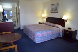una habitación de hotel con una cama y una mesa en American Inn and Suites White Hall, en White Hall