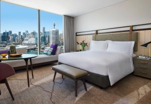 
a hotel room with a bed and a desk at Sofitel Sydney Darling Harbour in Sydney
