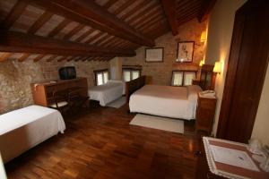 sypialnia z 2 łóżkami i biurkiem w pokoju w obiekcie Agriturismo Le Vescovane w mieście Longare