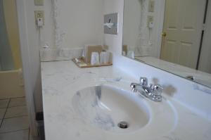 Un baño con un lavabo blanco y un espejo. en American Inn and Suites White Hall, en White Hall 33 fotos más