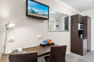 a room with a desk with a television on the wall at Best Western Kimba Lodge in Maryborough