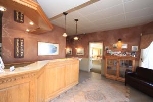 a large kitchen with wooden cabinets and a living room at Motel Grand-Pré Inc in Bonaventure