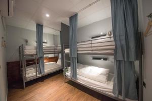 two bunk beds in a room with wooden floors at Deer Traveler 行鹿 in Yuchi