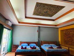 Un pat sau paturi într-o cameră la Buasawan Resort & Restaurant