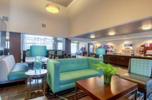 eine Lobby mit einem Sofa, Stühlen und einem Tisch in der Unterkunft Holiday Inn Express Hotel & Suites Carlsbad Beach, an IHG Hotel in Carlsbad
