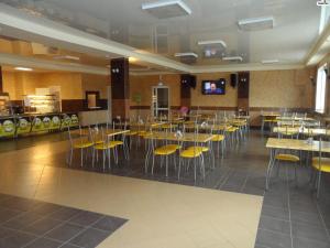 アブザコヴォにあるHotel Smileのダイニングルーム(テーブル、黄色い椅子付)