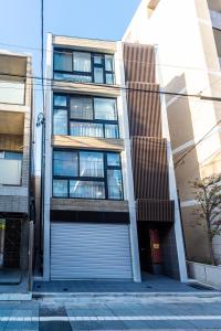 an apartment building with a garage door in a city at GIVE Araiyakushi in Tokyo