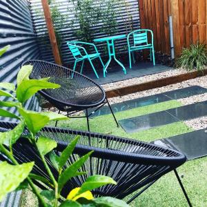 a patio with two chairs and a table and chairs at Tiny Tom - Hidden beside the river Mersey in Devonport