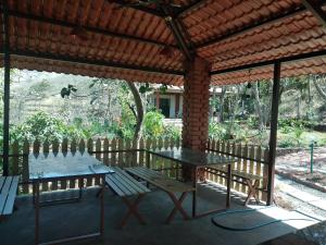 a patio with a table and benches under a pergola at teak trail in Pune