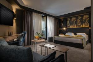a living room filled with furniture and a large window at Rosslyn Thracia Hotel Sofia in Sofia