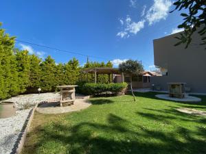 a backyard with a picnic table and grass at The Santo George Beach Resort in Amoudara Herakliou