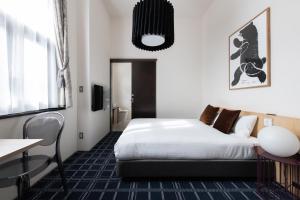 a hotel room with a bed and a desk at HakoBA Hakodate by THE SHARE HOTELS in Hakodate