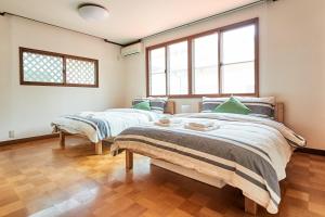 - 2 lits dans une chambre avec 2 fenêtres dans l'établissement Villa Shibuya, à Tokyo