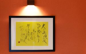 a picture hanging on a wall with a light at Shiki Homes KURUMI in Osaka