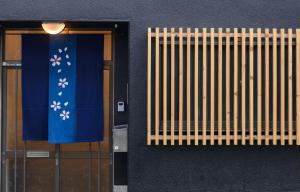 a building with a door and a blue and white curtain at Shiki Homes KURUMI in Osaka