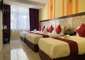 a hotel room with two beds with red pillows at SUN INNS PERMAS JAYA in Johor Bahru