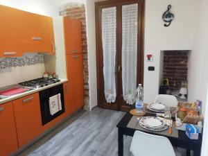 une cuisine avec des armoires orange et une table avec des chaises dans l'établissement CASA FREJUS . COMODO AL CENTRO E AL POLITECNICO BUS 33 E 42, à Turin
