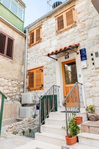 a stone building with stairs leading to a door at House of Cyril in Split