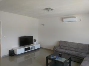a living room with a couch and a flat screen tv at Korkyra Melaina in Korčula
