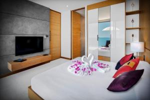 a hotel room with two beds and a tv at Jamahkiri Resort & Spa - SHA Plus in Koh Tao