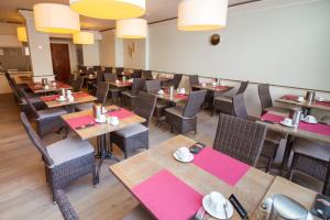 une salle à manger avec des tables, des chaises et des lumières dans l'établissement Hotel Paradisio by WP Hotels, à Blankenberge
