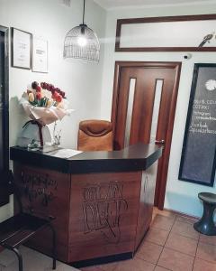 a wooden table with a vase of flowers on top of it at Capsularhouse Hostel in Dnipro