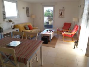 sala de estar con sofá, mesa y sillas en Appart 2 personnes proche plage de la Fresnaye, en Saint-Cast-le-Guildo