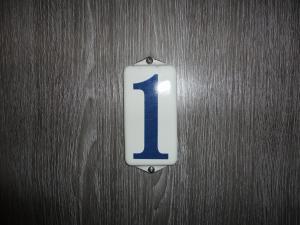 a sign with the number one on a wooden wall at De Vier Seizoenen in Renesse