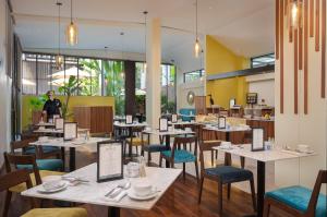 a restaurant with tables and chairs and a person in the background at The Aviary Hotel in Siem Reap