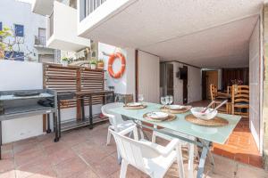 a patio with a table and chairs and a grill at Goldhome - Port Petit - Casa 4 habitaciones, amarre, wifi, aire acondicionado in Empuriabrava