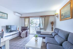 Una sala de estar con un sofá y un televisor. en Goldhome - Port Petit - Casa 4 habitaciones, amarre, wifi, aire acondicionado, en Empuriabrava