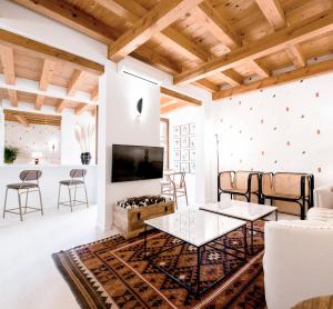 a living room with white walls and wooden ceilings at ~TÍVOLI~ Edificio Histórico S.XVI. Centro in Toledo