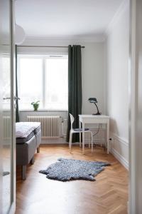 a bedroom with a desk and a bed and a table at Sköna Hönor Apartments in Visby