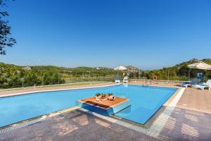 een groot zwembad met een tafel en stoelen bij Seven Springs Villas in Kolimbia