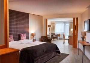 A bed or beds in a room at Das Alpenhaus Kaprun inkl Zell am See-Kaprun Sommerkarte