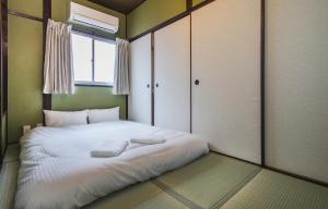 a bedroom with a bed with two towels on it at Shiki Homes KURIKO in Osaka