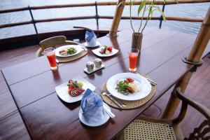 une table avec des assiettes de nourriture au-dessus d'un bateau dans l'établissement Yathra Houseboat, à Bentota