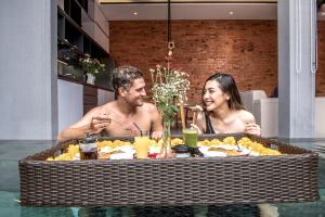 a man and woman sitting at a table eating food at Villa DeDayuh Seminyak in Seminyak +64 photos