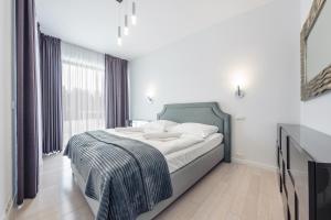 a bedroom with a bed and a large window at Apartamenty Sun & Snow Dune B in Mielno