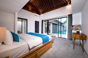 a bedroom with a bed and a view of a pool at Villa DeDayuh Seminyak in Seminyak