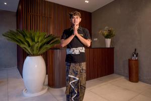 a young man is standing in a room with his hands in his mouth at Villa DeDayuh Seminyak in Seminyak