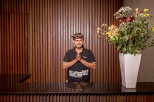 a man is standing in front of a table with his hands in prayer at Villa DeDayuh Seminyak in Seminyak