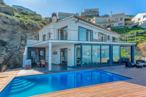 ein Haus mit einem Swimmingpool davor in der Unterkunft Flateli Port de la Selva in Port de la Selva