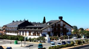 a large building with cars parked in a parking lot at Santa Susanna Resort in Santa Susanna