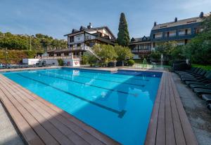 a large swimming pool with a house in the background at Santa Susanna Resort in Santa Susanna