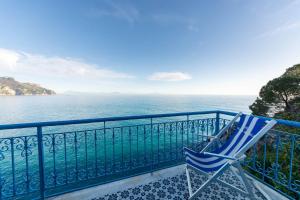 una silla azul sentada en un balcón con vistas al océano en Hotel Villa San Michele en Ravello