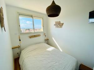 een kleine slaapkamer met een bed en een raam bij "MER" Séjour détente tout confort, magnifique vue sur la mer in Canet-en-Roussillon