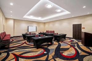 a conference room with tables and chairs and a podium at La Quinta by Wyndham Tuscaloosa McFarland in Tuscaloosa