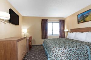 um quarto de hotel com uma cama e uma televisão em Days Inn by Wyndham Carbondale em Carbondale